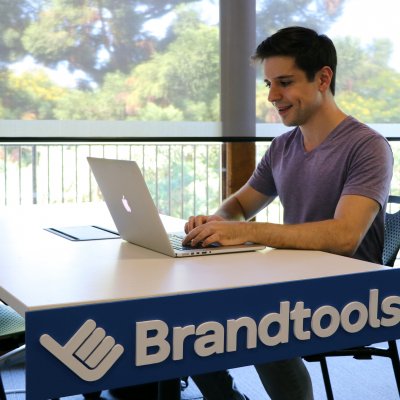UQ alumnus Nick Georgiou works his laptop at a Brandtools desk